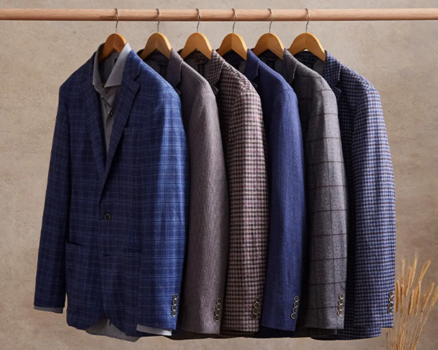 Assortment of plaid and gingham blazers hangin on a rack